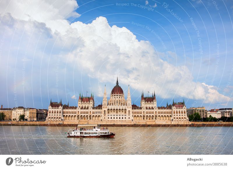 Hungarian Parliament Building in Budapest, Hungary, Danube river with passenger boat and dramatic sky. budapest parliament building hungary danube city landmark