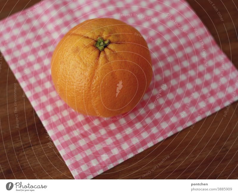 An orange one is lying on a checked napkin on a table. Vitamin C, good for the immune system Orange citrus fruit Healthy Fruit Fresh Table Food Healthy Eating