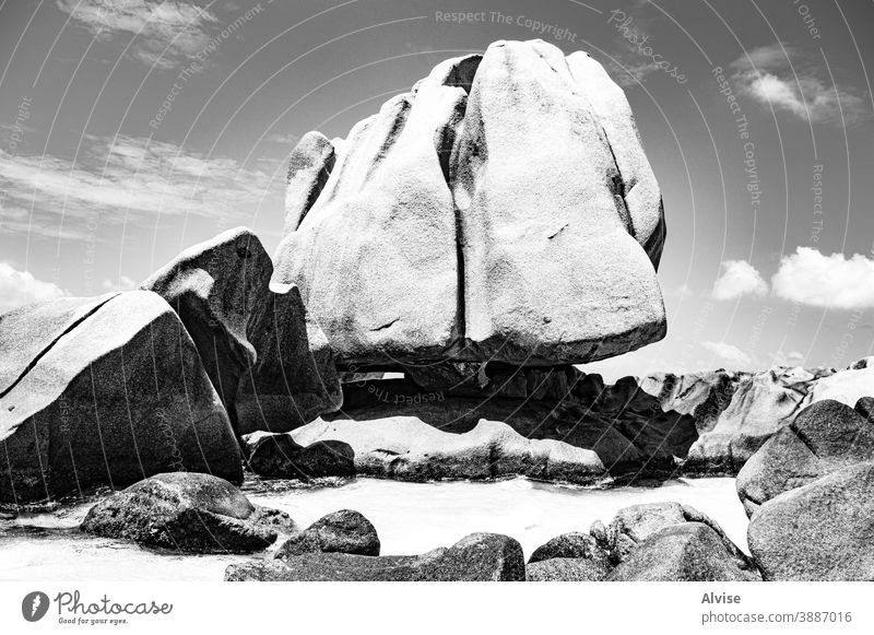 Granite monolith floats in the ocean like a giant iceberg seychelles tropical granite eroded travel nature landscape background rock erosion sand stone boulders