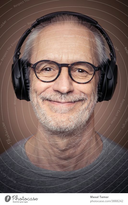 Portrait of adult man with beard wearing stereo headset and glasses. attractive audio boy casual caucasian cheerful concept cool device digital earphones