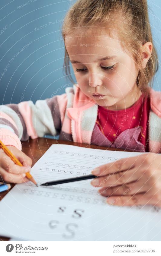 Little girl preschooler learning to write letters with help of her mother attention caucasian child childhood cute education educational fun home kid little