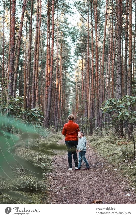 Mother and her little daughter walking in a forest during summer vacation trip active activity destination enjoy exploration female green hike lifestyle nature