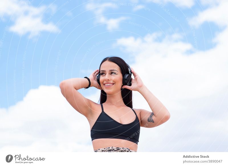 Happy woman with headphones on street fit using happy cheerful listen active positive young music wireless mobile workout gadget device lifestyle sportswoman