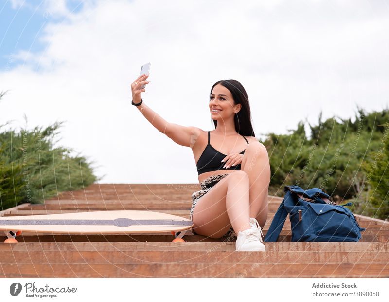 Happy woman with longboard taking selfie on street smartphone fit happy smile positive sporty mobile female young device lifestyle cheerful optimist