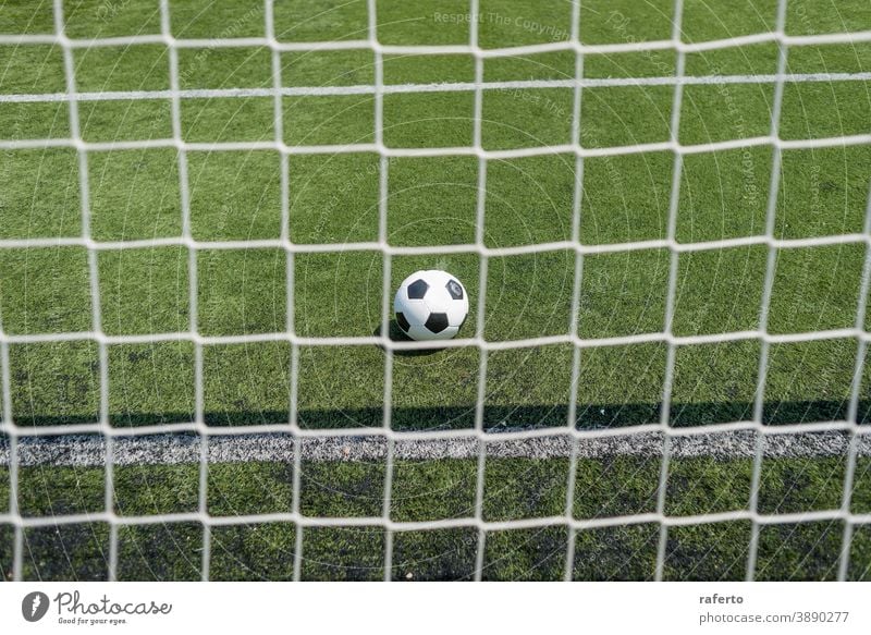Vintage Soccer ball on green football field grass against net soccer goal no people background outdoor play pitch nobody game sport soccer field retro line