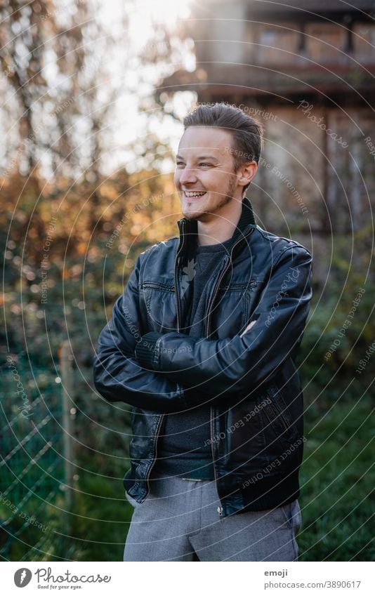 young man in leather jacket outside Outdoors Green masculine more adult Cool (slang) Upper body arms folded Profile Young man Man Friendliness Positive
