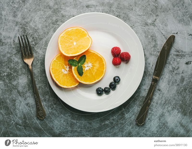 Healthy dessert.White plate with orange slices,raspberries,blueberries and vintage old cutlery healthy breakfast healthy dessert raspberry fitness fruit nature