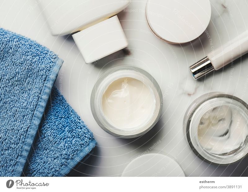 Skincare products.Cream jars,lotion, exfoliating cream and a blue towel dermatology hygiene brush cosmetic product health packaging container body tube