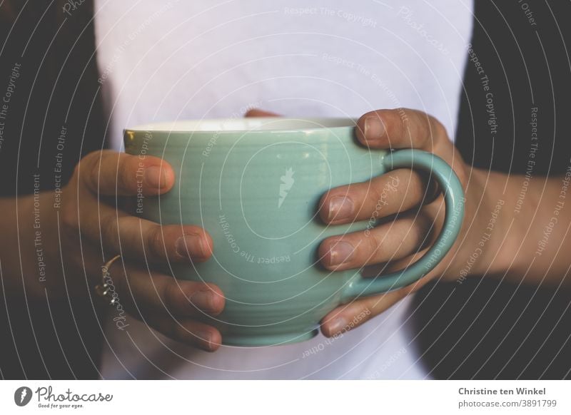 Close-up of a large light green cup of coffee or tea in the hands of a young woman. Cup Mug stop To hold on Coffee Tea Bright green Black White Beverage Tea cup