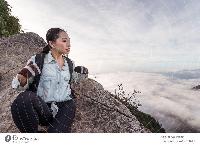 Asian woman sitting on rock in mountains traveler cloud highland admire breathtaking hiker explorer enjoy female asian ethnic yuanzui mountain taiwan wanderlust