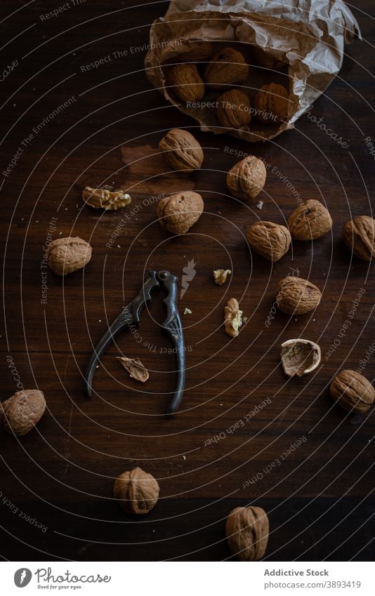 Walnuts and nutcracker on wooden table walnut kernel shell food pile ingredient natural whole raw edible nutrition heap meal snack brown culinary product