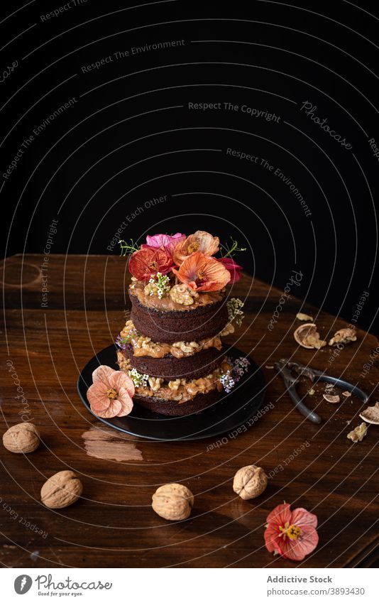 Tasty chocolate cake with walnuts served on table flower rustic dessert sweet food festive cut pastry naked cake gourmet confectionery delectable delicious