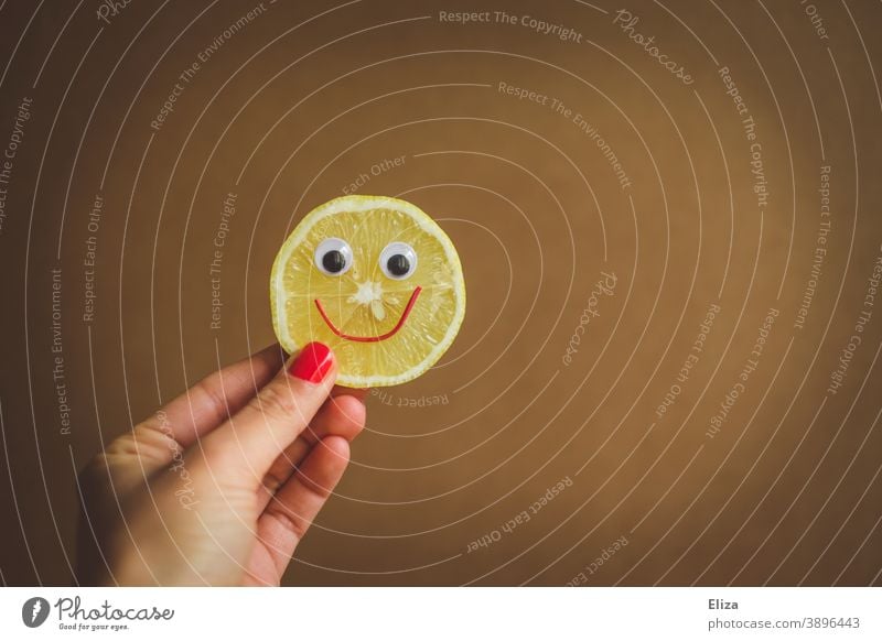 Sauer macht lustig - A hand holds a slice of lemon with a laughing face Lemon Funny Face Sour cheerful Slice of lemon vitamins salubriously Vitamin C Yellow