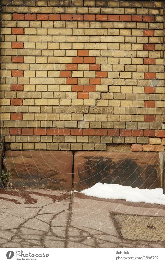 Last snow in front of a brick wall with staircase crack Wall (barrier) Bricks sheep Crack & Rip & Tear Asphalt background Decompose Beige cracks