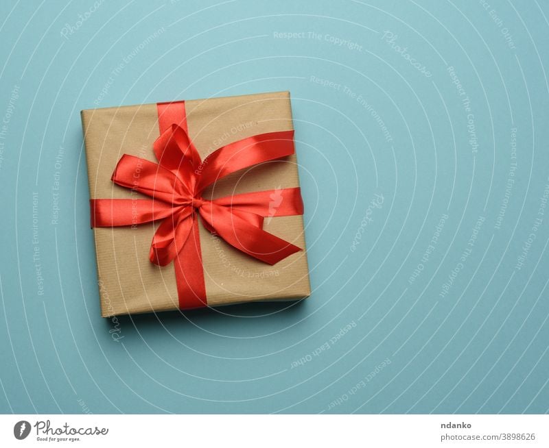 Three gifts in beige wrapping paper tied with brown ribbons on brown Stock  Photo - Alamy