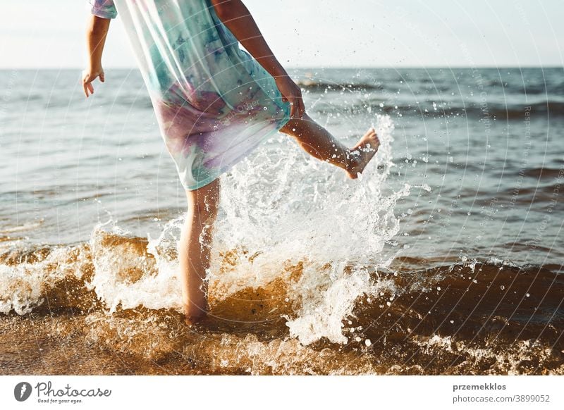 Girl spending a free time jumping splashing in a sea on a beach during summer vacation excited enjoy positive sunset emotion carefree nature outdoors travel