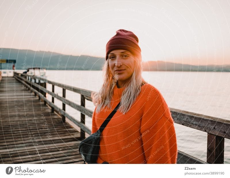 Young woman in the evening sun at lake Attersee Lake Attersee sunset Evening Sunset Nature Dusk Landscape Idyll Austria Footbridge Lakeside Exterior shot Orange