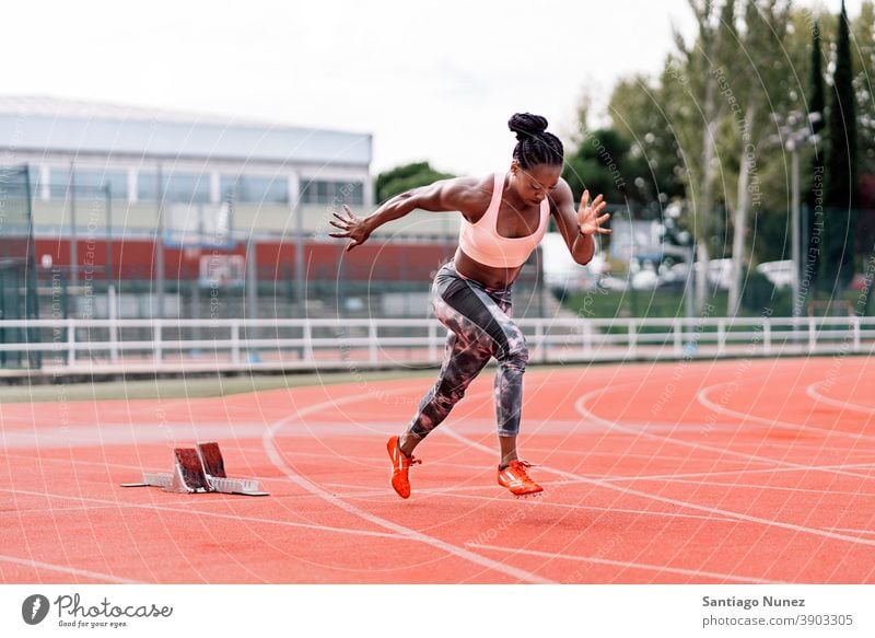 African-American athlete sprinter jumping a hurdle - a Royalty