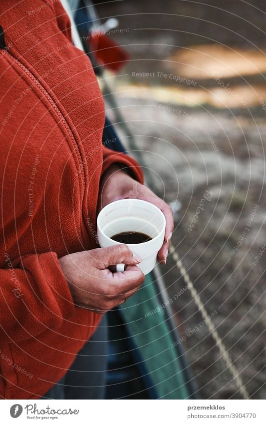 Close up of woman sitting outdoors holding cup with coffee above hiker wanderer trip wanderlust exploration lifestyle picnic camp freedom vacation travel