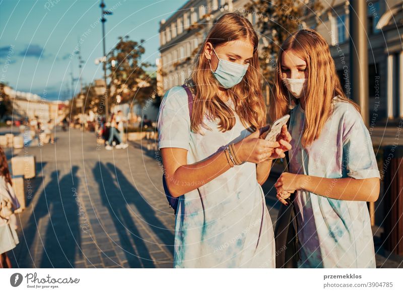 Young women girls using smartphones wearing the face masks to avoid virus infection caucasian cellphone conversation covid-19 female lifestyle mobile outbreak