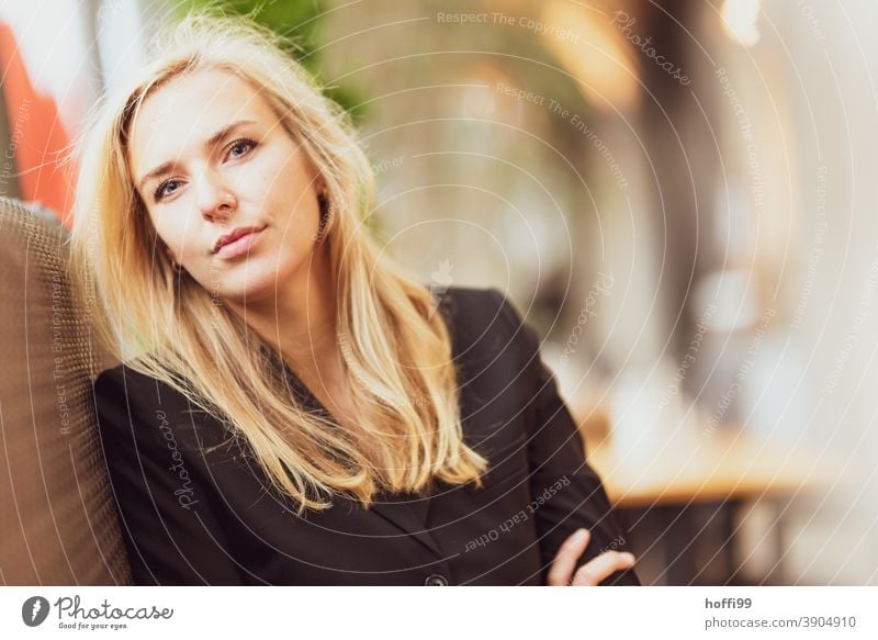 the young woman in the cafe looks friendly into the camera Young woman smiling woman Lifestyle Fashion Elegant Face of a woman Looking into the camera Feminine
