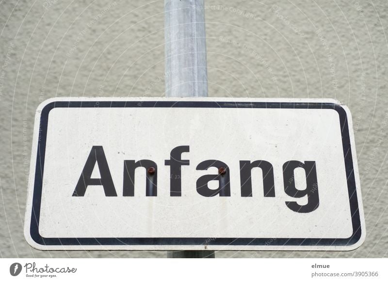 the white, framed metal plate reads "Anfang" in black block letters / Anbruch / Beginning start sign Communication Starting point rudiment beginning of the end