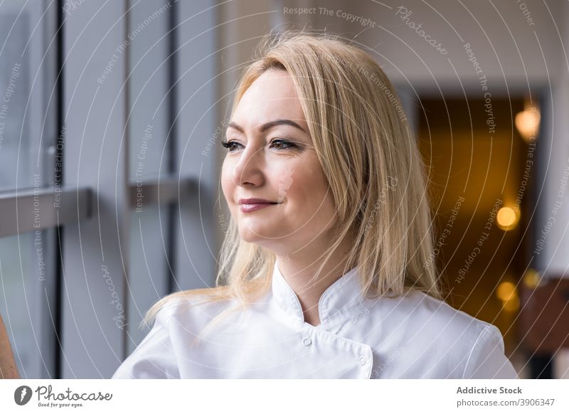 Female doctor in white uniform standing in corridor of hospital medic woman smile clinic window hallway female professional cheerful job specialist staff