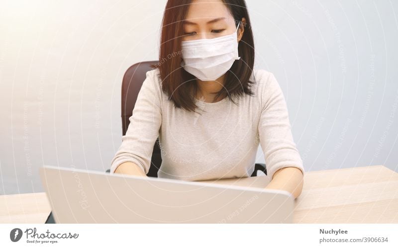Young asian woman wearing hygienic mask using computer laptop in home office, prevent the pandemic of Covid-19 and Coronavirus, work from home and self quarantine concept