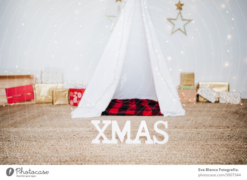 Christmas decoration at home, lights, teepee and presents. Christmas time christmas tent plaid blanket december decorated white tree house indoors holiday