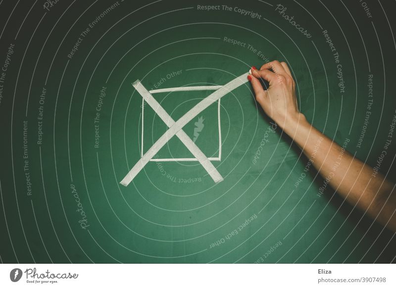 Hand makes a cross on a blackboard. Going to vote. choice Select Crucifix Vote policy German federal elections Election campaign Decide Word call authored