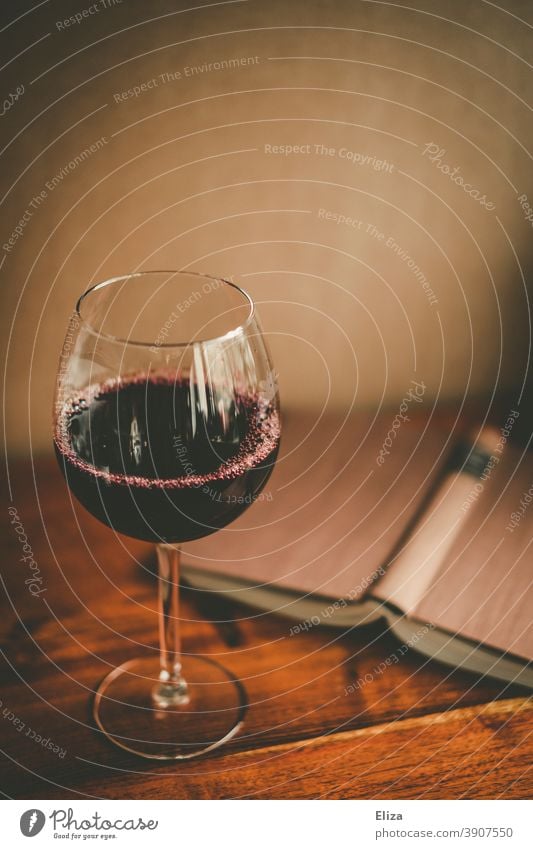A glass of red wine and an open book. Time for yourself. Book Vine Glass Reading Wine glass Red wine relaxation Alcoholic drinks Time to yourself To enjoy