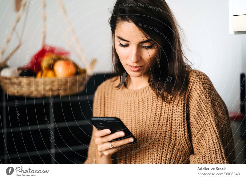 Woman drinking coffee and browsing smartphone woman home kitchen relax cup weekend domestic female counter internet surfing mobile social media connection