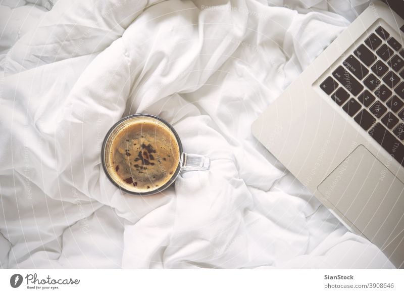 Working in bed , laptop and cup of coffee on white bed book morning blanket home room bedroom light beautiful lights isolated background lifestyle work house