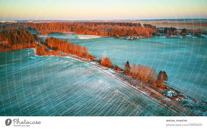 Colorful trees December sunset Aerial scene. Rural dirt road. Countryside top view. field snow winter crop aerial agriculture evening nature landscape covered