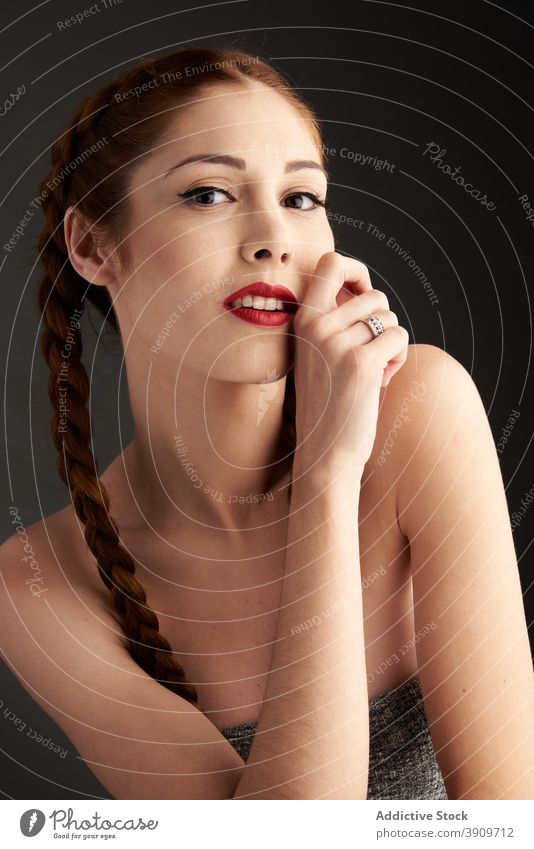 Woman with braids in studio looking at camera redhead hairstyle woman appearance charming trendy red hair female red lips model personality individuality