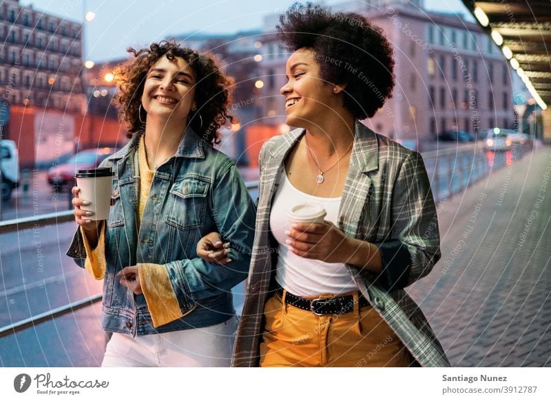 Afro Girl and Friend Having Fun cup of coffee walking street friends drinking women multi-ethnic afro girl caucasian portrait having fun front view friendship