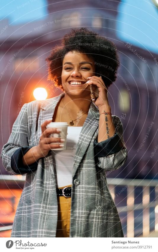 Happy Afro Woman Using Phone standing using phone phone call calling cup of coffee front view afro portrait black woman street city life cellphone smartphone