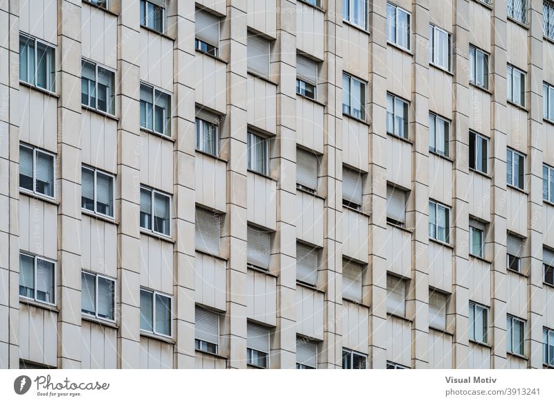 Rows of windows with roller shutters on the facade of an urban building architecture exterior structure construction metropolitan edifice abstract modern rows