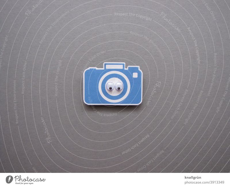 Small blue paper camera with two wiggle eyes wobbly eyes Looking Eyes Looking into the camera Paper Low-cut Colour photo Blue White Gray Black