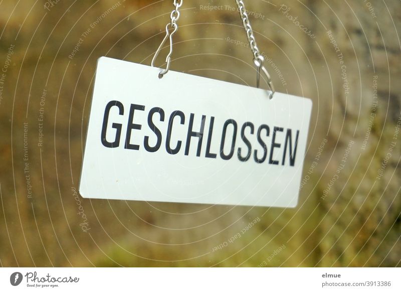 Behind a glass pane hangs a sign "GESCHLOSSEN" / lockdown / Corona crisis Closed Hang Glass door Pane corona crisis Signage Load business prevention shutdown