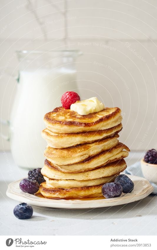 A stack of buttermilk pancakes breakfast food fluffy dessert delicious sirup meal sweet homemade white maple gold plate honey pile fresh morning baked snack