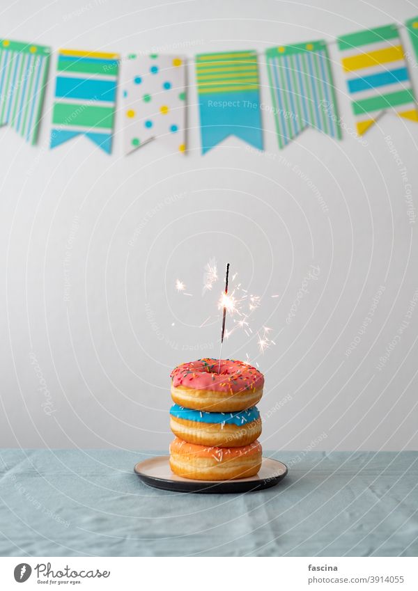 Birthday donuts cake with sparkler on table - a Royalty Free Stock Photo  from Photocase