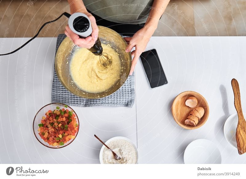Woman in kitchen cooking a cake. Hands beat the dough with an electric mixer, top view woman recipe ingredients food person home female caucasian diet meal