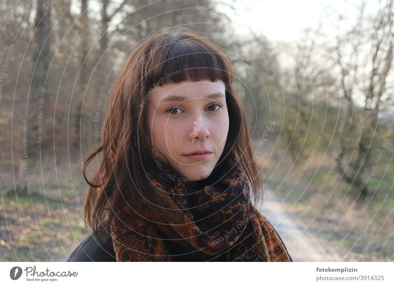 Portrait of a bare young woman with long, brown hair and natural