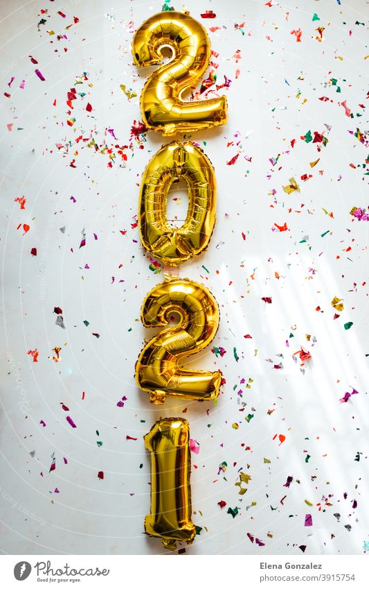 Gold foil balloons numeral 2021 with colorful confetti on white background. Happy New year 2021 celebration. numbers years invitation congratulations glossy