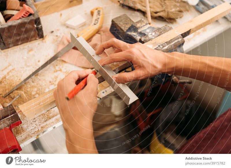 Crop woodworker using metal angle in workshop carpenter man carpentry plank male piece craftsman garage craftsmanship instrument tool equipment job pencil busy