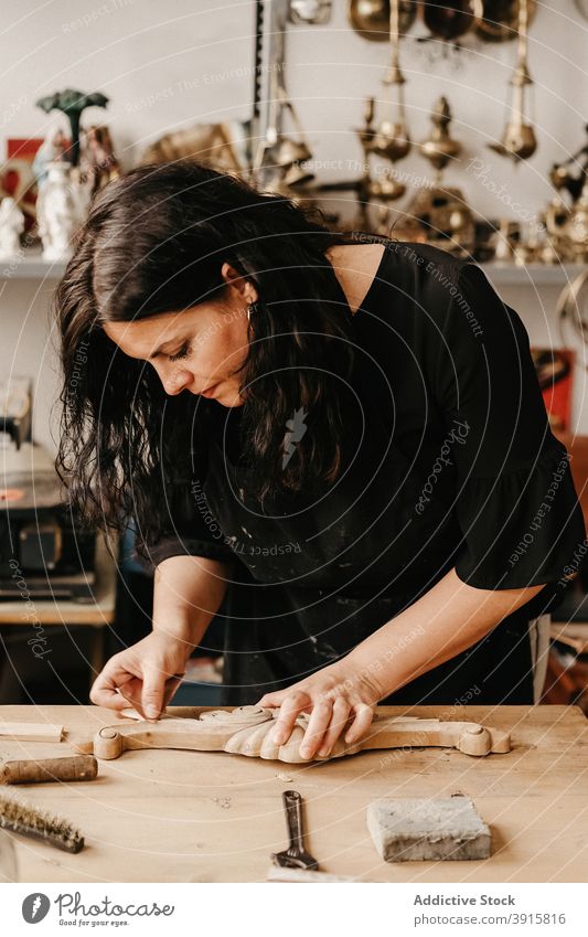 Craftswoman polishing wooden detail in workshop craftswoman carpenter woodwork carve create professional workplace woodworker timber carpentry handmade