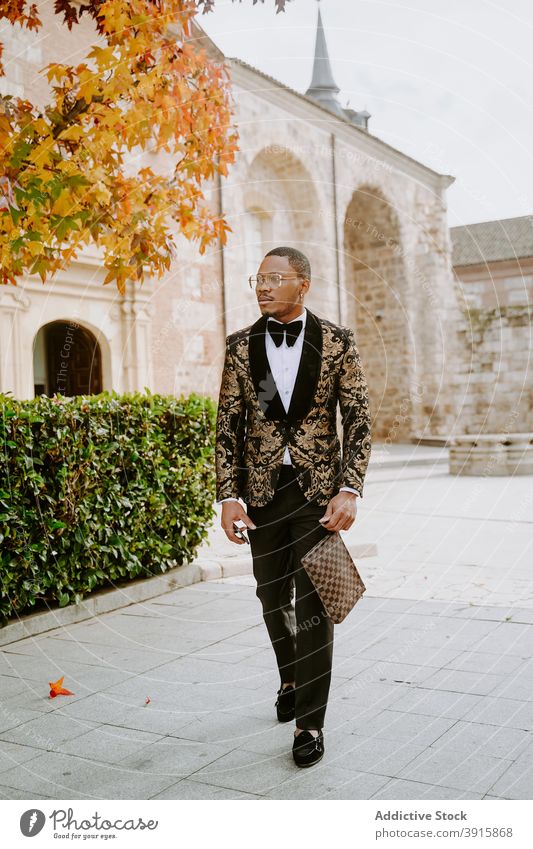 Stylish black man in posh suit in city tuxedo luxury rich style walk expensive street male ethnic african american costume fashion trendy gentleman handsome