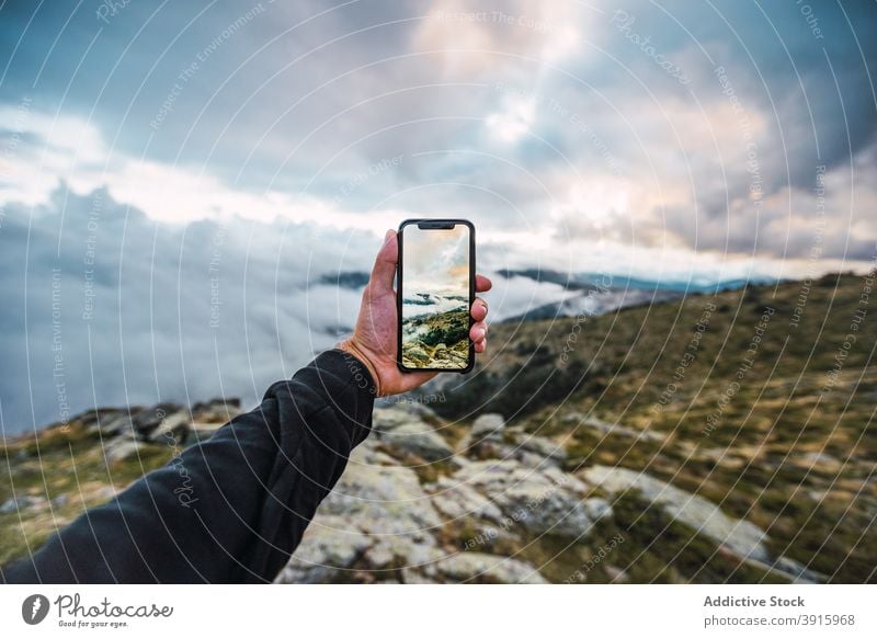 Crop traveler taking picture of highlands on smartphone take photo mountain incredible nature terrain rocky hiker male mobile adventure device gadget tourism