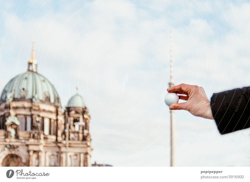 Golf ball held in front of Berlin television tower Berlin TV Tower Downtown Berlin Landmark Television tower Alexanderplatz Sky Berlin Cathedral